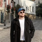 Man walking on sunny cobblestone street in Alfortville, France with historic houses.